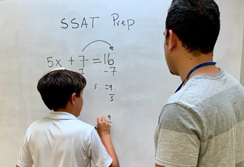 SSAT TestPrep student doing a Math problem on a board